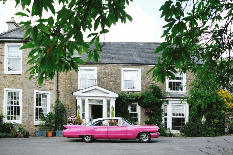 Wild Roots Kitchen & Bar Pink Cadillac outside The Old Rectory wedding venue. Image by Lloyd Williams Photography