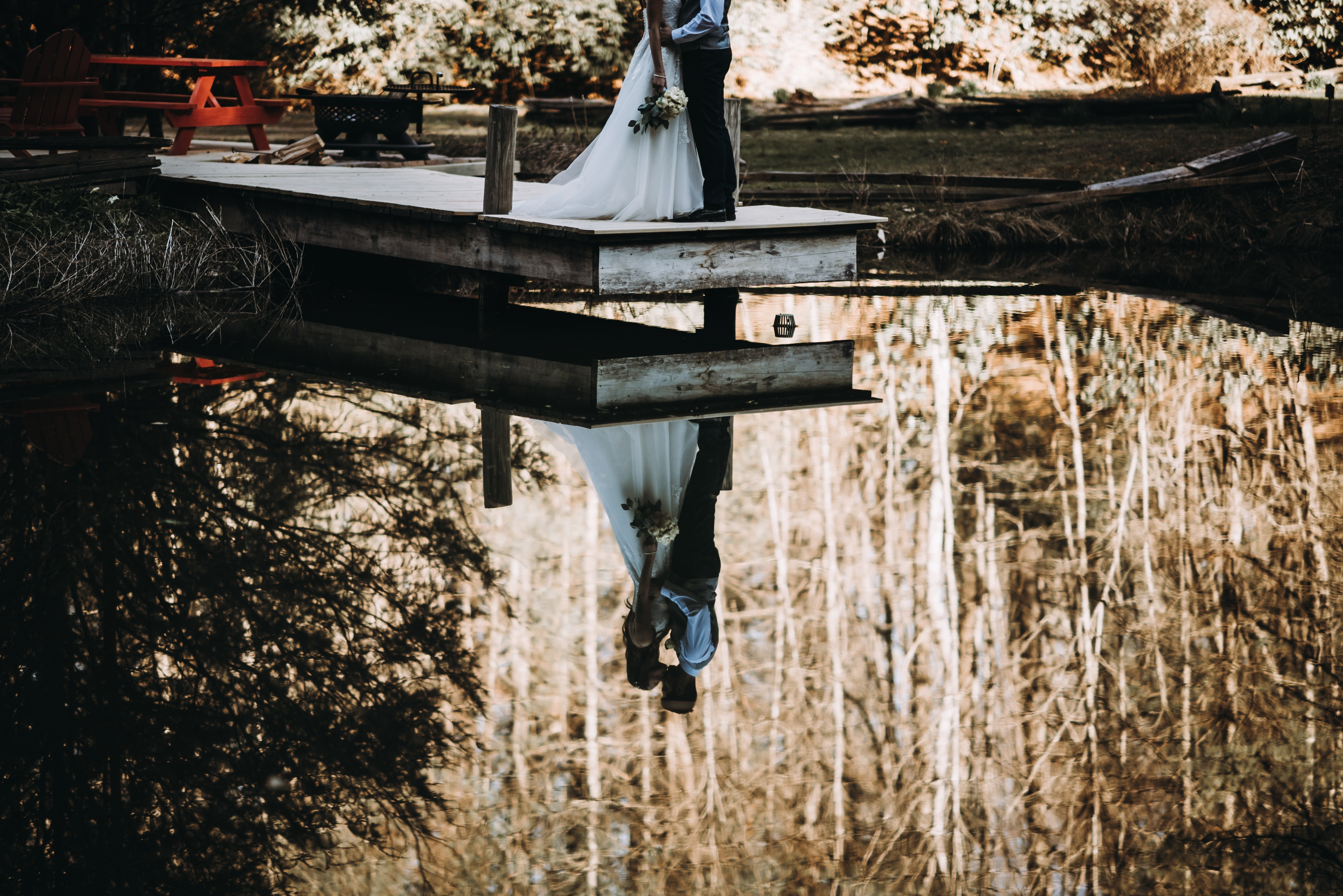 Wedding couple reflected in lake carbon footprint of wedding catering